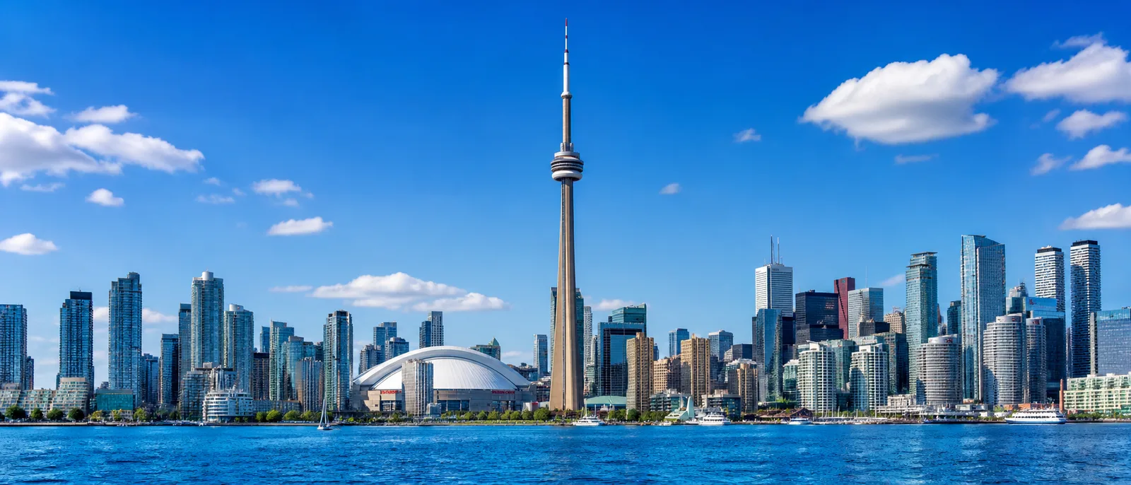 Wide Toronto skyline panorama with blue sky and waterfront